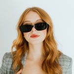 Frau mit dunkler, rechteckiger Sonnenbrille