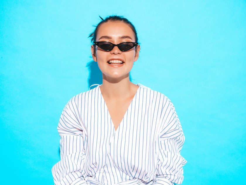 Frau mit Sonnenbrille auf blauem Hintergrund