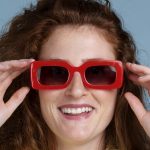Rothaarige Frau mit roter Sonnenbrille