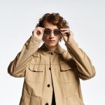 Junger Mann mit Brille und beiger Jacke