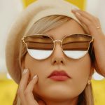 Blonde Frau mit Mütze und Sonnenbrille