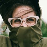 Frau mit Brille mit Jacke im Wind