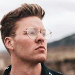 Junger Mann mit goldener Metallbrille