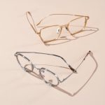 Goldene und silberne Brillenfassung auf beigem Hintergrund