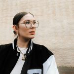 Frau mit College-Jacke und Brille