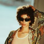 Frau mit Sonnenbrille und bunter Bluse