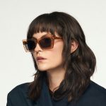 Dunkelhaarige Frau mit brauner Sonnenbrille